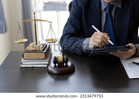 Lawyer's office. Justice with scales and judge hammer at lawyer working on laptop legal documents and the concept of justice