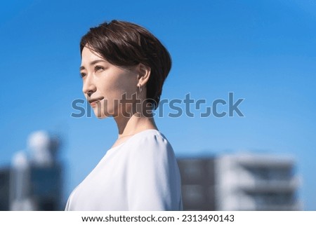 Japanese business woman looking at  the clear sky Royalty-Free Stock Photo #2313490143