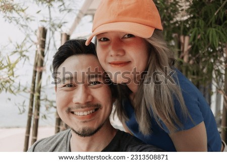 Selfie portrait of lovely and cheerful asian couple hug and kiss.