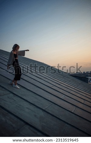 Photo shoot on the roof. Young woman posing in the roof at sunset.  People, lifestyle, relaxation concept.