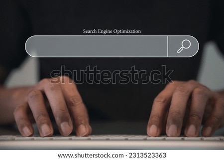 Man's finger indicating the search icon on a dark background, while using a computer keyboard for searching and browsing internet data. The networking and searching concept is highlighted