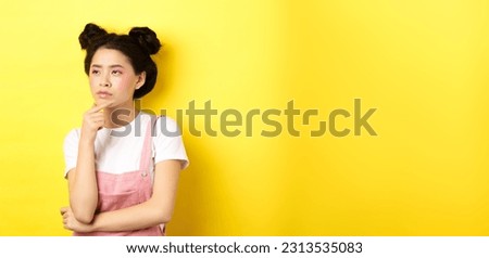 Thoughtful serious girl with beauty makeup, looking left and thinking with suspicious face, have doubts, standing on yellow background.