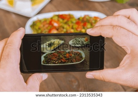 Food blogger using smartphone taking photo .Mans hands make phone photography of Oriental traditional meals. lunch or dinner. For social media, blogging.  Healthy food