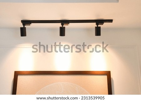 Spotlights illuminate the pictures on the wall for a dimensional look. Add warmth to your home with Mood and Tone Modern