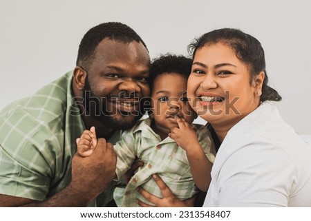 Happy family relationship moments, portrait african american handsome father and beautiful Asian mother in healthy good mood taking pictures together with innocent cute half Thai-Nigerian son baby.
