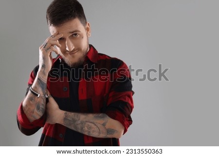 Portrait of handsome hipster man on light grey background. Space for text
