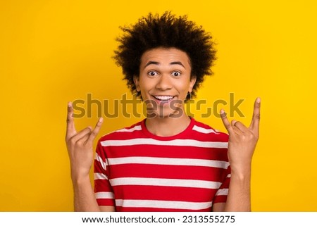 Photo of excited positive person toothy smile hands fingers demonstrate heavy metal symbol isolated on yellow color background