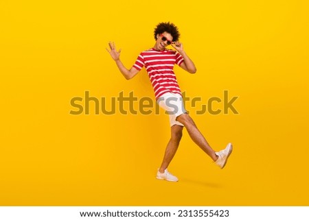 Full size photo of funky guy dance summer vacation active person wear shirt pants shoes sun specs isolated yellow color background