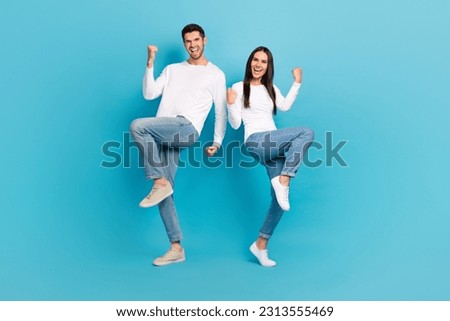 Full length photo of two delighted crazy people raise fists luck accomplishment isolated on blue color background