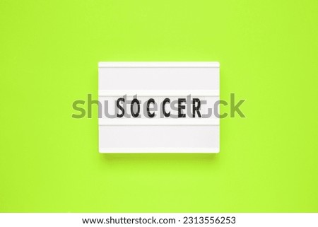 The word soccer on lightbox isolated green background.