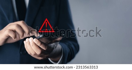 System warning hacked alert, cyber attack on computer network.Businessman using mobile phone with warning sign notification error, Malicious software,virus and cybercrime, Cybersecurity,data breach.