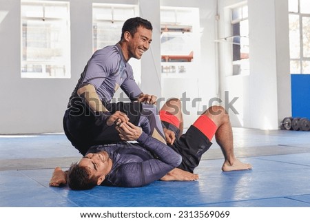 People laugh together in gym, martial arts and fitness with combat, jiu jitsu and students learning self defense skills. Fight, exercise and MMA with fighting sport and men with fun and train at dojo Royalty-Free Stock Photo #2313569069