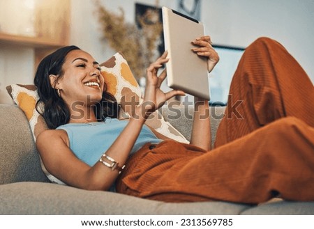 Woman relax on sofa with tablet, online streaming with internet and reading ebook or watching film at home. Happy female person with technology, subscription and mobile app with break in living room Royalty-Free Stock Photo #2313569785