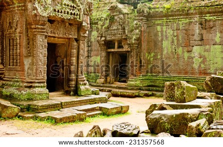 Ficus Strangulosa tree growing over a doorway in the ancient ruins of Ta Prohm at the Angkor Wat site in Cambodia Royalty-Free Stock Photo #231357568