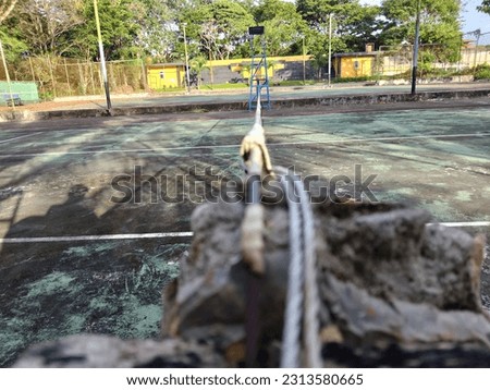 a rope used to spread a net on an outdoor tennis court used to separate the court between opposing players