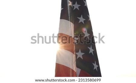 Close up waving American USA flag on natural outdoor setting with sun ray flare nature outdoor background. Fourth of July, Independence Day, 4th of July, Memorial Day, Veterans Day, Labor Day Concept