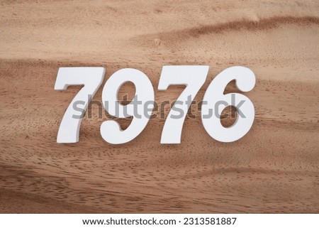 White number 7976 on a brown and light brown wooden background.
