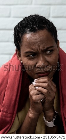 African American woman sitting at home wrapped in blanket crying feeling depressed sad and angry, victim of racism, street crime and strong racial insults. Black female strength and independence. Royalty-Free Stock Photo #2313593471