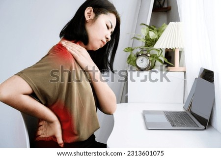 Asian Woman suffering Neck, Shoulder, and Lower Back Pain due to Office Syndrome from Prolonged Computer Work Royalty-Free Stock Photo #2313601075