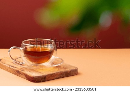 Glass cup of black tea on beige table Royalty-Free Stock Photo #2313603501