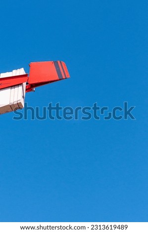 bottom view, far distance of, a concrete, counter weight and cradle for a commercial crane, against a blue sky