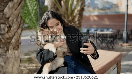 Young hispanic woman with dog smiling confident make selfie by smartphone at park