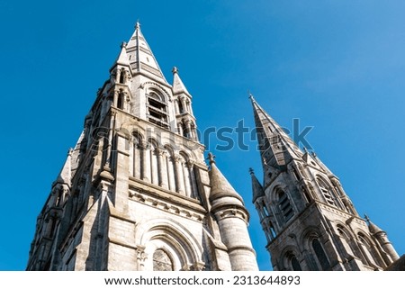 The tall Gothic spire of an Anglican church in Cork, Ireland. Neo-Gothic Christian architecture. Cathedral Church of St Fin Barre, Cork - Ireland’s Iconic Buildings. Royalty-Free Stock Photo #2313644893