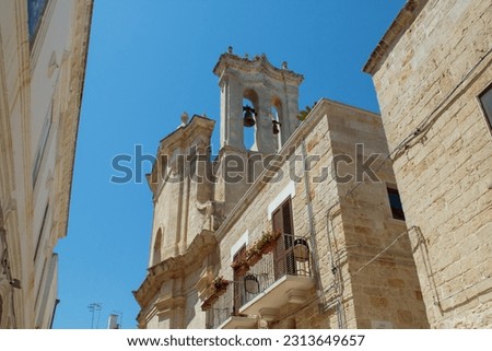 Bell tower of the Purgatory Rectory Church in Polignano a Mare, Italy. Church located among the narrow streets of the historic part of the city on a sunny summer day. Royalty-Free Stock Photo #2313649657