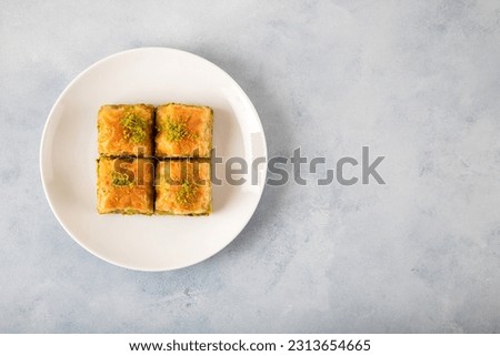 Pistachio baklava on a white plate,top view Royalty-Free Stock Photo #2313654665