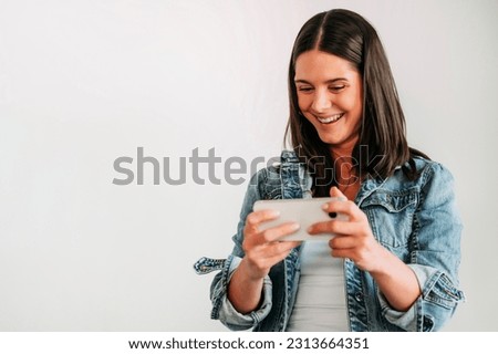 Euphoric woman looking at her smartphone and raising her arm.
