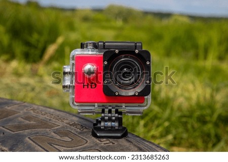 Action camera on a green background on a sunny day. Royalty-Free Stock Photo #2313685263