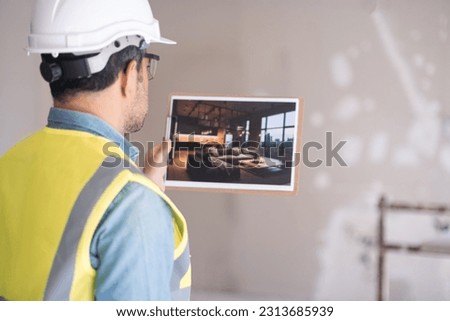 Professional engineer looking at picture with modern living room design in loft style man in protective helmet and west imagining apartment interior after renovation process