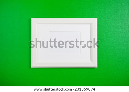 blank picture frame on a green wall 