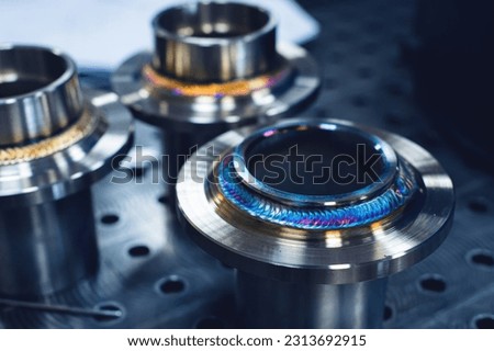 Freshly welded seam on a stainless flange. Production of metal products from stainless steel by welding Royalty-Free Stock Photo #2313692915