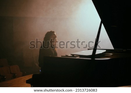 The woman plays the piano in hall