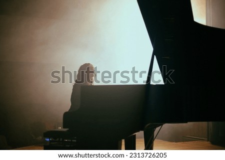 The woman plays the piano in hall