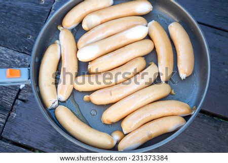 Close up of fried hotdog sausage on pan for serving  