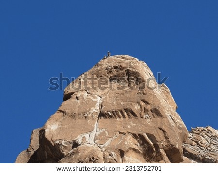 clear blue sky and climbers on the peak of a bariloche mountain