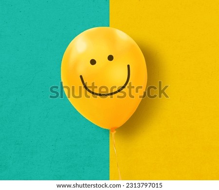 Yellow balloon with smile on blue and yellow texture background. Concept of positive thinking