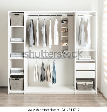 a small white walk in closet with open shelving and shelves holding baskets Royalty-Free Stock Photo #2313814719