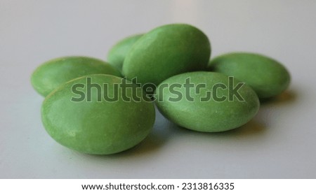 A close-up of a handful of green chocolate pastilles.