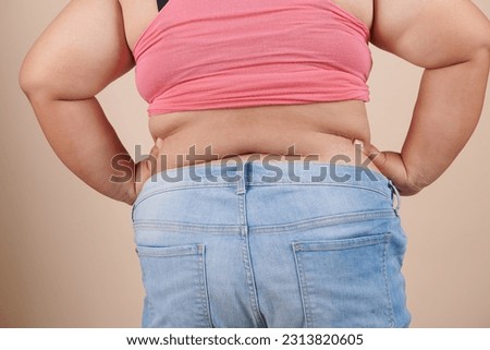 she wants to lose weight concept of abdominal fat surgery., the girl takes extra fat on sides of her stomach with her hand. isolate on white background, Type with increased fat deposition and fullness