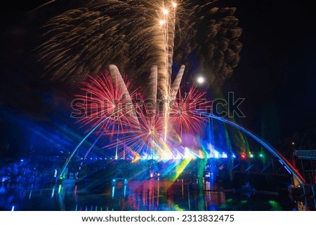 Light  and  sound  firework  display 
on long  wooden  bridge  with  night  sky  background at  Paknam  Rayong  district ,famous  landmark ,Rayong  Province ,Thailand.
