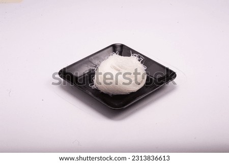 Glass Noodles for shabu arranged in black plastic tray on a white background