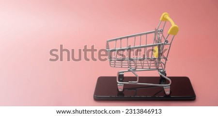 Online shopping on smart phone for global concept. shopping cart with a smartphone on pink background. buy in the online shop by mobile app. Easy shopping with fingertips for consumers. eCommerce.