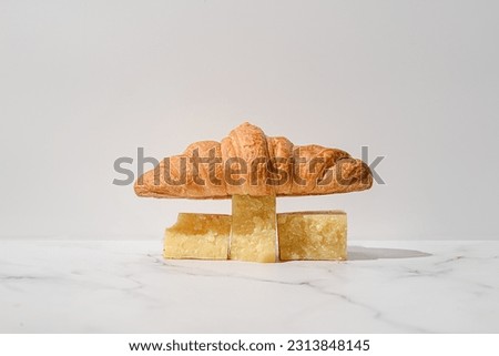 croissant with cheese on a white background. balancing composition in the style of modern minimalism
