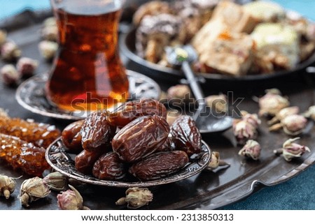 Turkish  tea in glass cup  with date fruits in traditional copper serving set,  selective focus with shallow depth of field