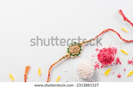 Raksha Bandhan, Indian festival with beautiful Rakhi and Rice Grains. A traditional Indian wrist band which is a symbol of love between Sisters and Brothers Royalty-Free Stock Photo #2313881527