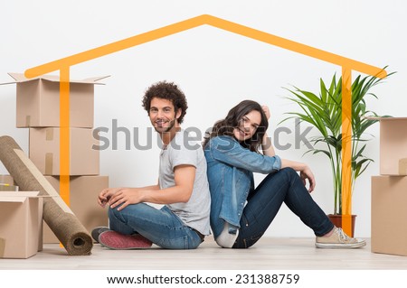 Smiling Young Couple Sitting Back To Back After Moving House Royalty-Free Stock Photo #231388759
