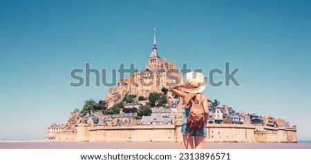 Rear view of woman looking at Le Mont Saint Michel- Normandie in France Royalty-Free Stock Photo #2313896571